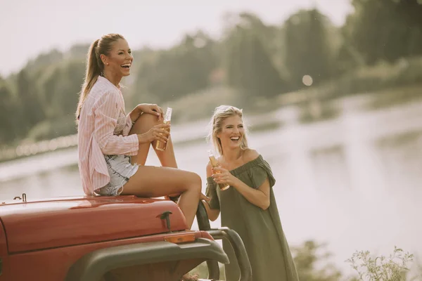 Дві Молоді Жінки Розважаються Капоті Автомобіля Річці — стокове фото