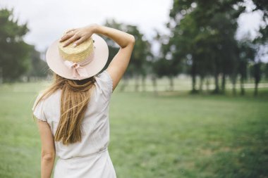 Arkadan Görünüş parkta genç kadın, kim şapka
