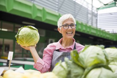 Kadın kıdemli organik sebze piyasasında satıyor
