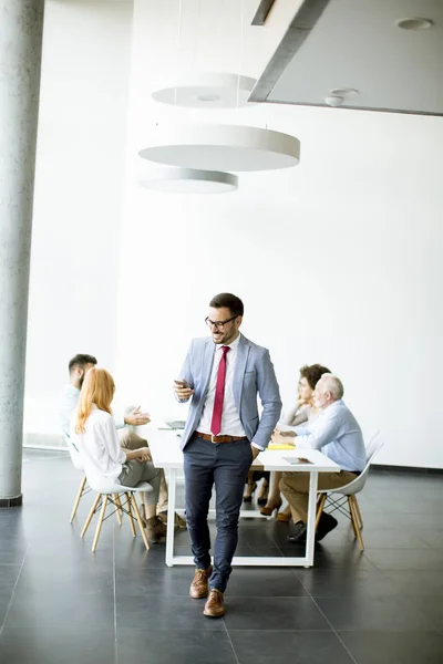 Young Businessman Using Mobile Phone Office While Other People Background — Stock Photo, Image