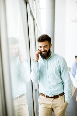 Genç işadamı Office diğer insanlar bir toplantıyı yapmak arka planda iken cep telefonunuzu kullanarak