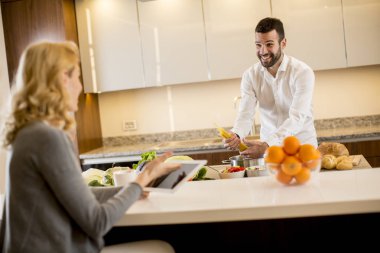 Delikanlı iken bir genç kadın oturuyordu ve modern bir mutfak tablet kullanımı bir yemek hazırlama