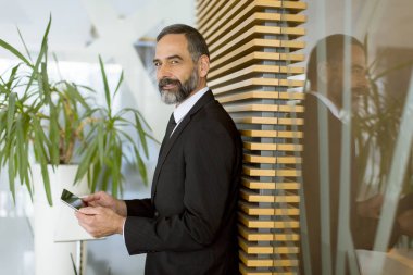 Yakışıklı orta yaş işadamı modern Office dijital tablet ile