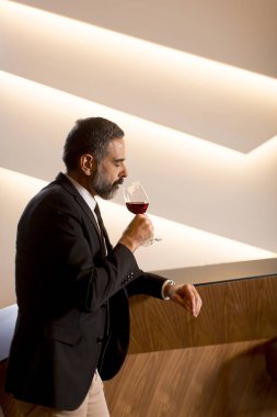 Kırmızı şarap kadehinin tatma yakışıklı olgun adam