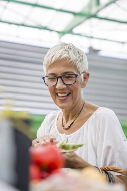 Taze organik sebze pazarında satın alma kadın kıdemli portresi