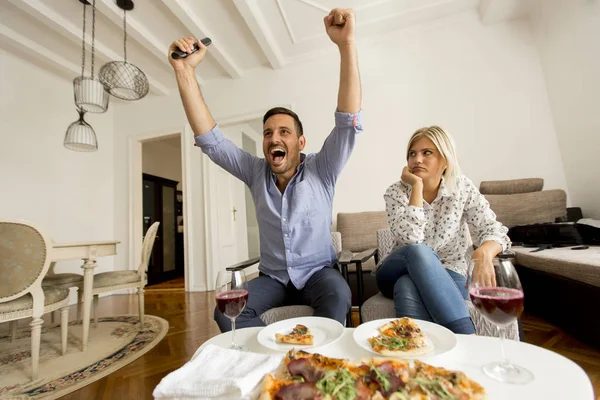 Pareja Joven Disfrutando Comer Pizza Mientras Hombre Mira Juego Televisión —  Fotos de Stock