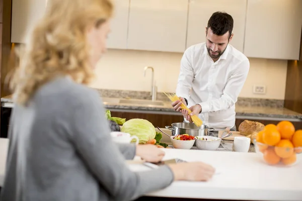 Young Man Preparing Meal While Young Woman Sitting Use Tablets — Stock Photo, Image