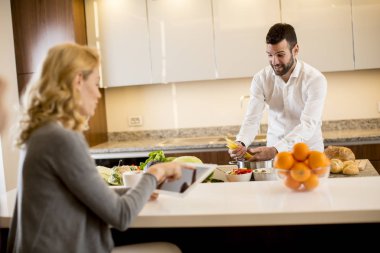 Delikanlı iken bir genç kadın oturuyordu ve modern bir mutfak tablet kullanımı bir yemek hazırlama