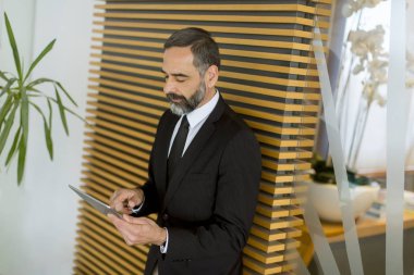 Yakışıklı orta yaş işadamı modern Office dijital tablet ile