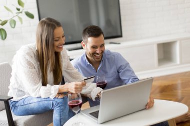 Odanın içinde laptop bakarak çarklı çift portresi