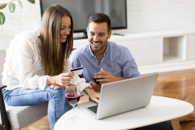 Odanın içinde laptop bakarak çarklı çift portresi