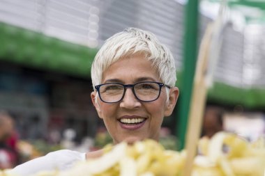 Taze organik sebze pazarında satın alma kadın kıdemli portresi