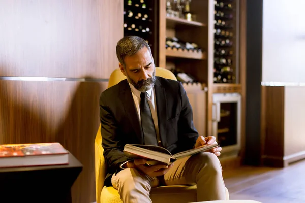 Handsome Senior Businessman Sittnig Reading Book Lobby — Stock Photo, Image
