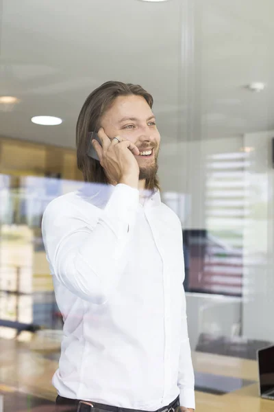 Jovem Feliz Usando Seu Telefone Inteligente Escritório Moderno — Fotografia de Stock