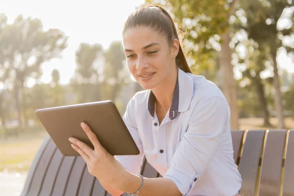 Joven Hermosa Chica Usando Tableta Mientras Está Sentado Banco Del — Foto de Stock