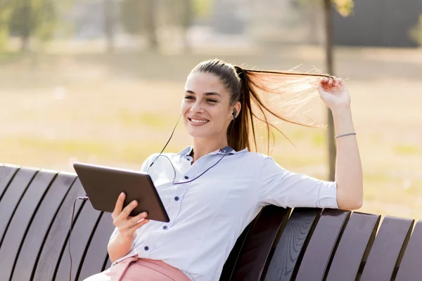 Jonge Vrouw Zittend Het Bankje Het Park Luister Muziek Een — Stockfoto