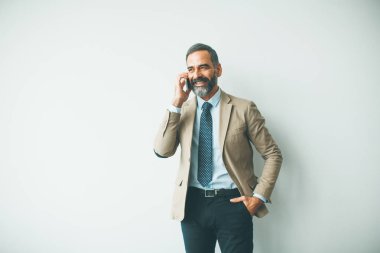 Ofiste cep telefonu konuşurken yakışıklı olgun işadamı