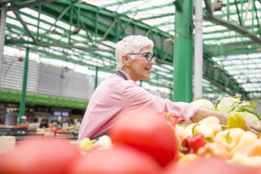Kadın kıdemli organik sebze piyasasında satıyor
