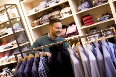 Dükkanında satın almak elbiselere bakarak bir genç çarklı adam portresi