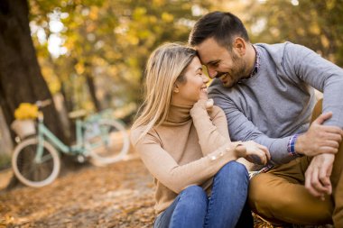 Sonbahar Park zeminde oturan çarklı genç çift