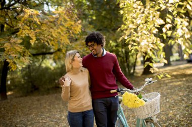 Parkta yürüyüş ve bisiklet iterek genç çok ırklı çift