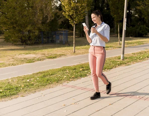 Mujer Joven Feliz Con Café Escuchando Música Teléfono Inteligente Caminando — Foto de Stock