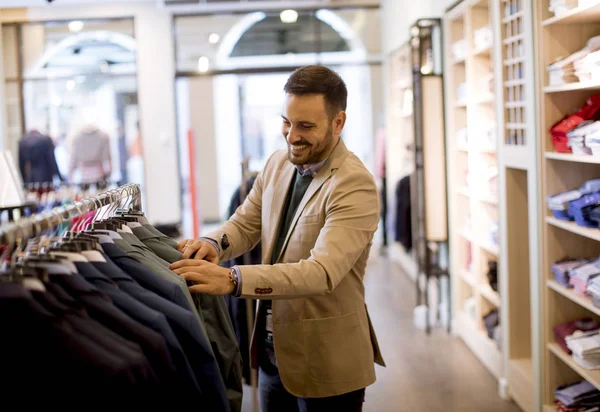 Handsome young man buying clothes in the store