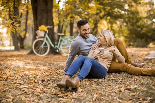 Fröhliches Junges Paar Sitzt Herbstpark Auf Dem Boden — Stockfoto