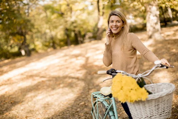 Jovem Alegre Com Bicicleta Usando Smartphone Parque Outono — Fotografia de Stock