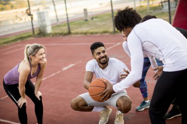 Gençlerin grup sahada basketbol oynarken çok ırklı