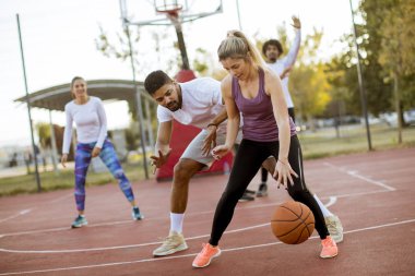 Gençlerin grup sahada basketbol oynarken çok ırklı