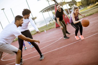 Gençlerin grup sahada basketbol oynarken çok ırklı