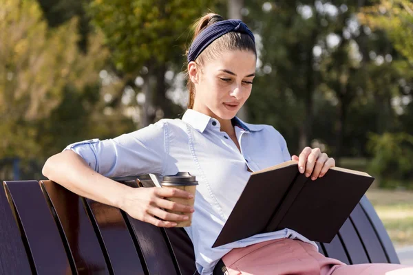 Ung Kvinna Sitter Träbänk Läsa Bok Och Dricka Kaffe — Stockfoto