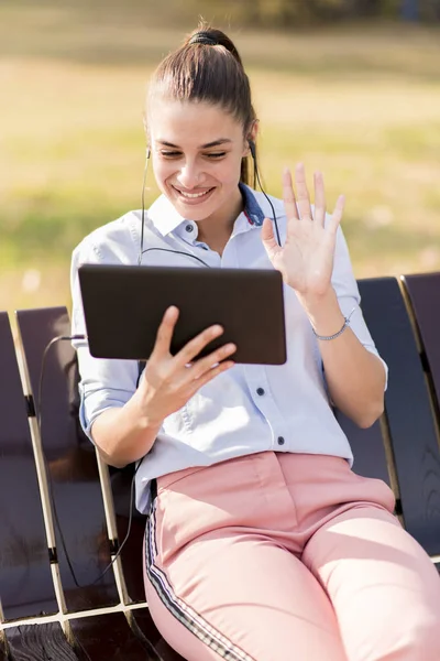 Mujer Joven Sentada Banco Parque Escuchar Música Una Tableta — Foto de Stock