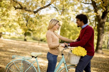 Çok ırklı çift bisiklet ayakta Sonbahar Park ile