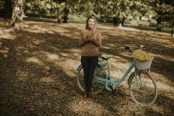 Joyeux Jeune Femme Avec Vélo Utilisant Smartphone Dans Parc Automne — Photo