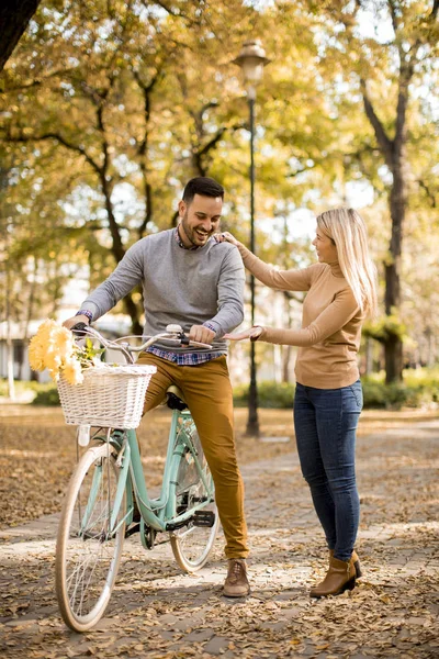活跃的年轻夫妇一起享受浪漫的步行与自行车在金秋公园 — 图库照片