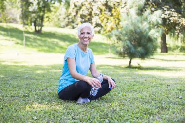 Mutlu üst düzey Bayan rahatlatıcı parkta eğitimden sonra