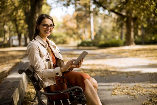 Mujer Sentada Banco Parque Durante Tiempo Otoño Utilizando Tableta Comprobar —  Fotos de Stock