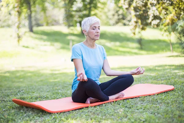 Senior Vrouw Lotus Staat Een Gras Park — Stockfoto