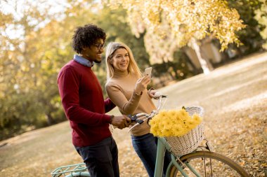 Çok ırklı çift bisiklet ayakta Sonbahar Park ile