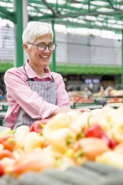 Kadın kıdemli organik sebze piyasasında satıyor