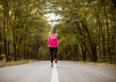 Orman iz altın sonbaharda çalışan genç fitness kadın