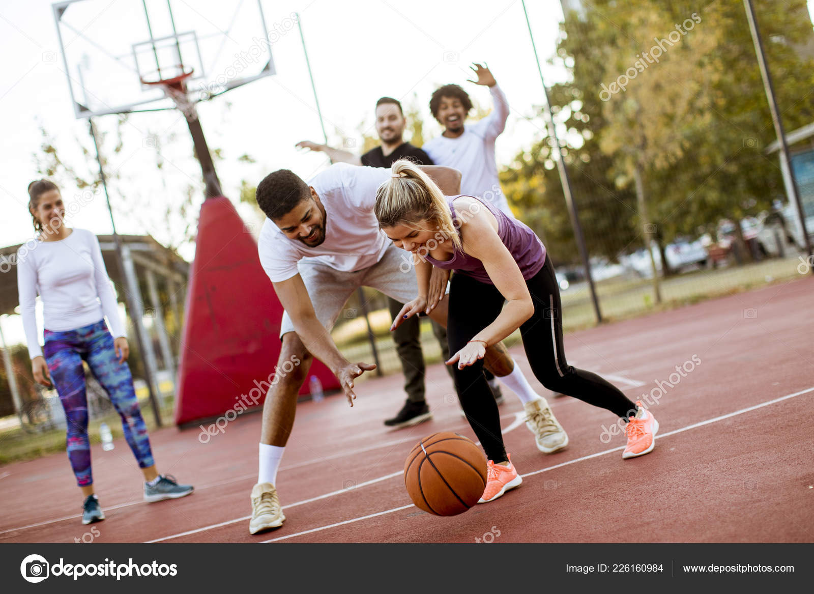 Foto de Grupo De Pessoas Multiétnicas Jogando Basquete Na Quadra e