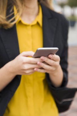 Genç işkadını üstünde hareket eden telefon içinde belgili tanımlık geçmiş ofis binaları ile açık mesajlaşma