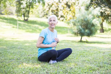 Mutlu üst düzey Bayan rahatlatıcı parkta eğitimden sonra