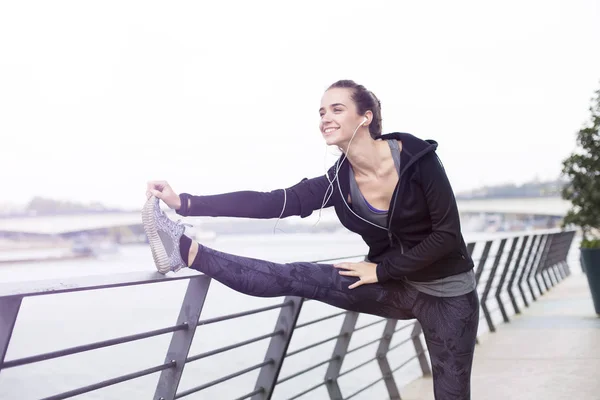 Ganska Ung Kvinna Med Hörlurar Stretching Sport Träning Urban Miljö — Stockfoto
