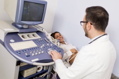 Doktor hastanın muayene ultra ses tarayıcı makine ile yapıyor