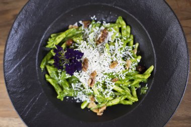 Makarna ıspanak pesto ve keçi peynirli masada plaka üzerinde