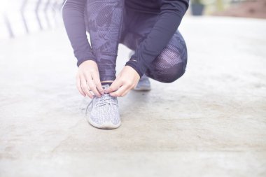 Sportif kadın koşu ayakkabıları antrenmandan önce üzerinde bağcık bağlama yönü göster